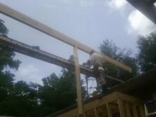 Carpenter setting a ridge beam over a new addition frame — Ice Dam Removal by Roofing Brothers in Pewee Valley