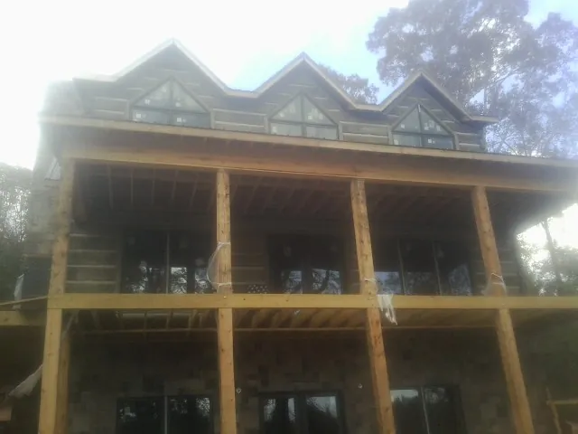 Dormers and porch framing on a large log home under construction — Roof Coating work by our crew in Pewee Valley