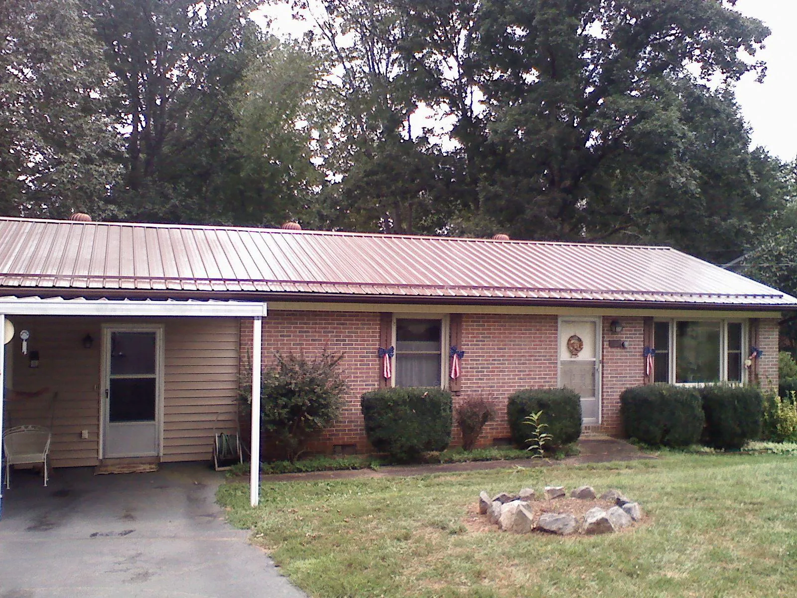 Bronze metal roof and carport on a brick ranch home — Roof Repair work by our crew in Pewee Valley